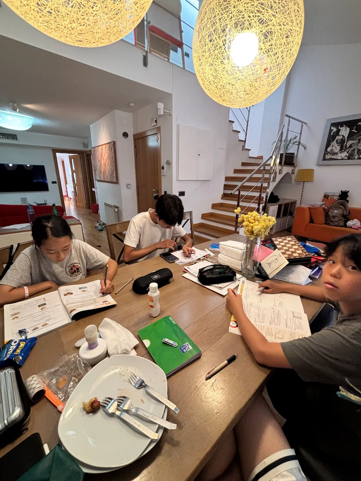 테이블에 둘러앉아 교재를 보며 공부하는 학생들